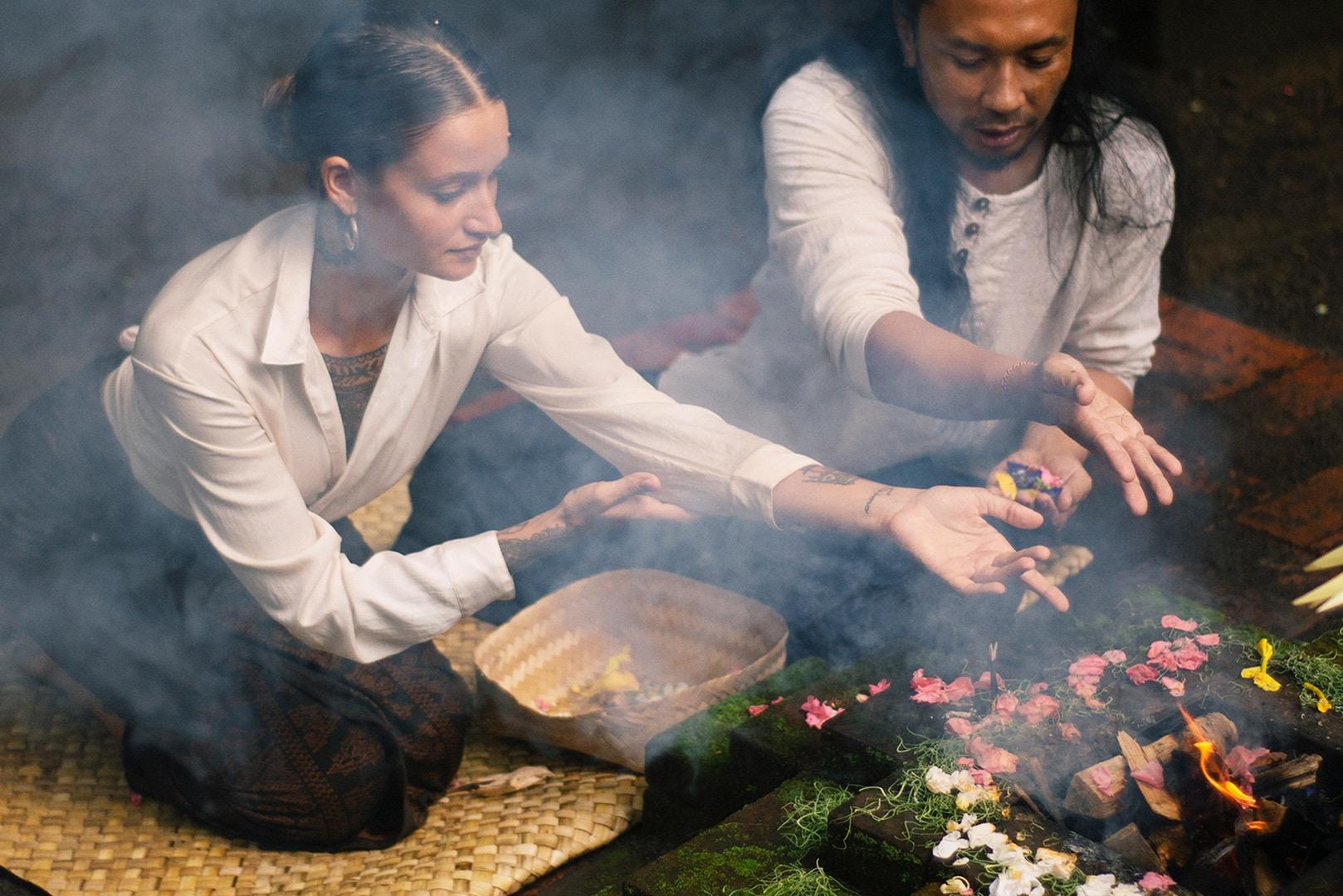 A local Welaka, or priest, reads a woman's palms as part of Buahan, a Banyan Tree Escape's Insight Journey
