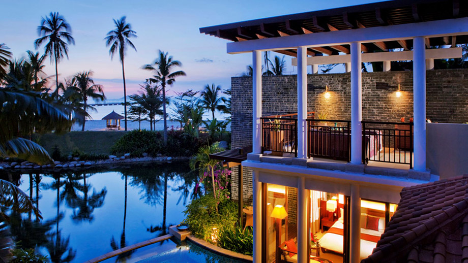 Resort villa overlooks pool with palm trees and ocean backdrop; Banyan Tree Sanya ambiance.