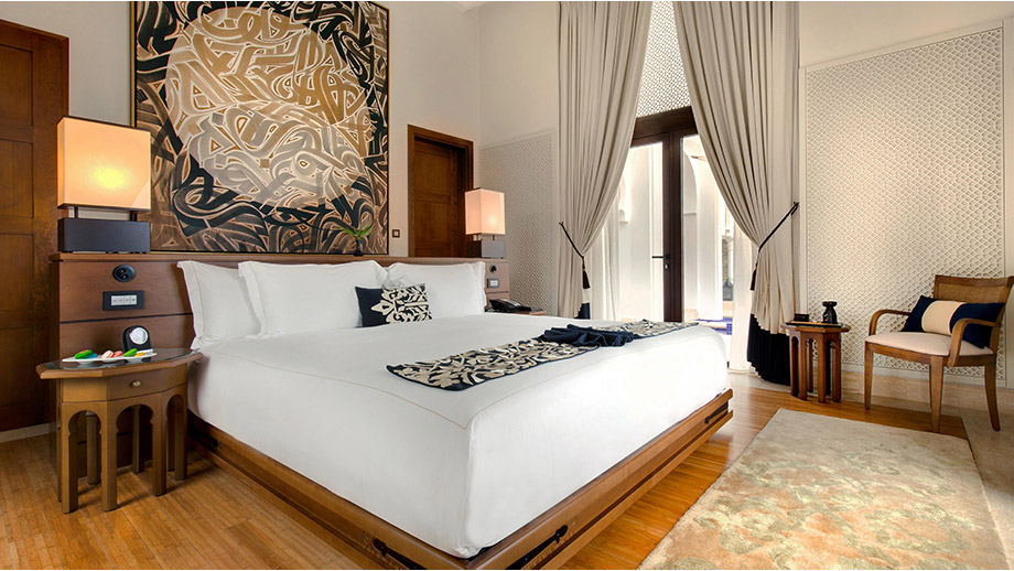 Luxurious bed with artistic headboard in Banyan Tree Tamouda Bay Morocco room.