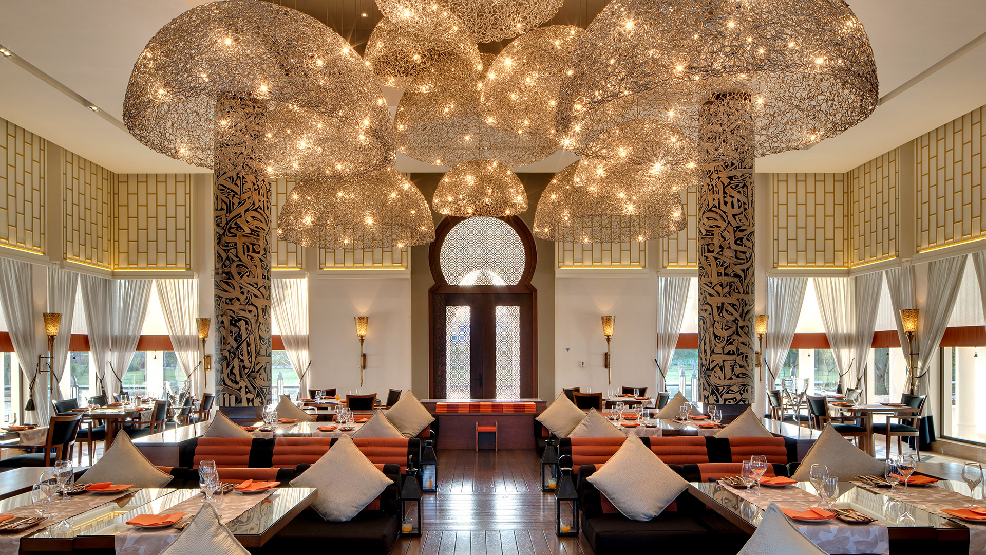 Elegant Saffron dining area with intricate chandeliers, at Banyan Tree Tamouda Bay resort.