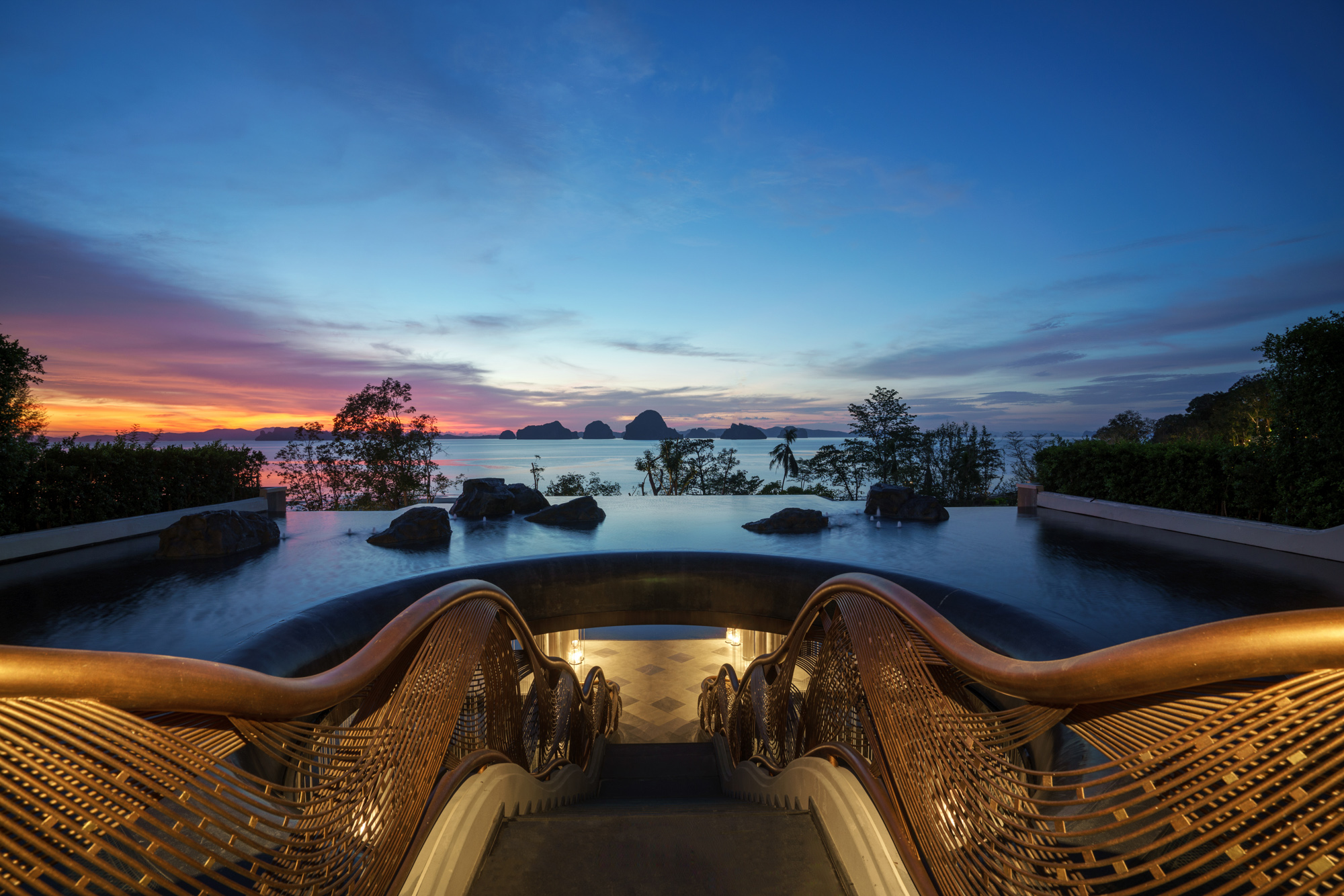 Elegant stairs lead to an infinity pool with a breathtaking sunset view at Banyan Tree Krabi Hotels & Resorts.