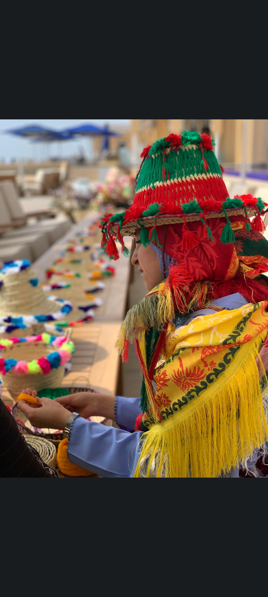 Local person creating colorful sustainable crafts at Banyan Tree Tamouda Bay.