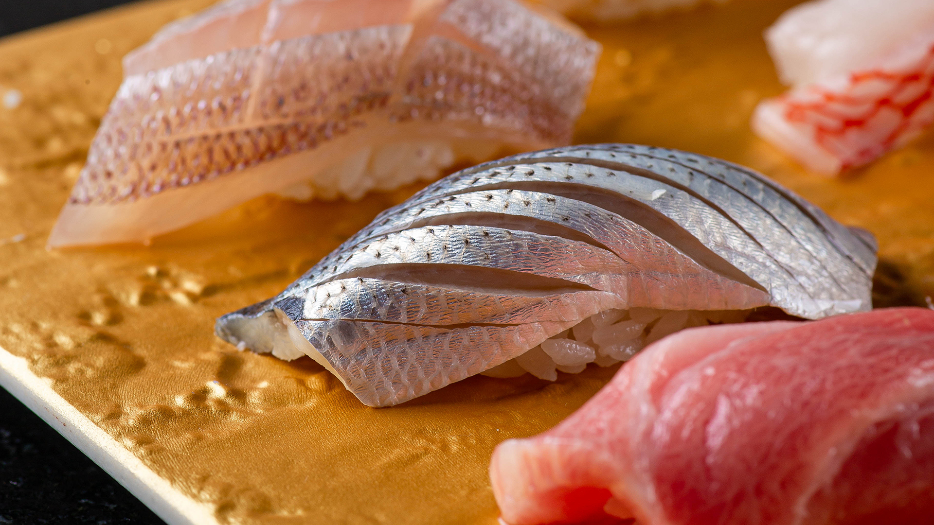 Elegant Takahisa restaurant bar with wooden stools, pendant lights; Banyan Tree Dubai ambiance.