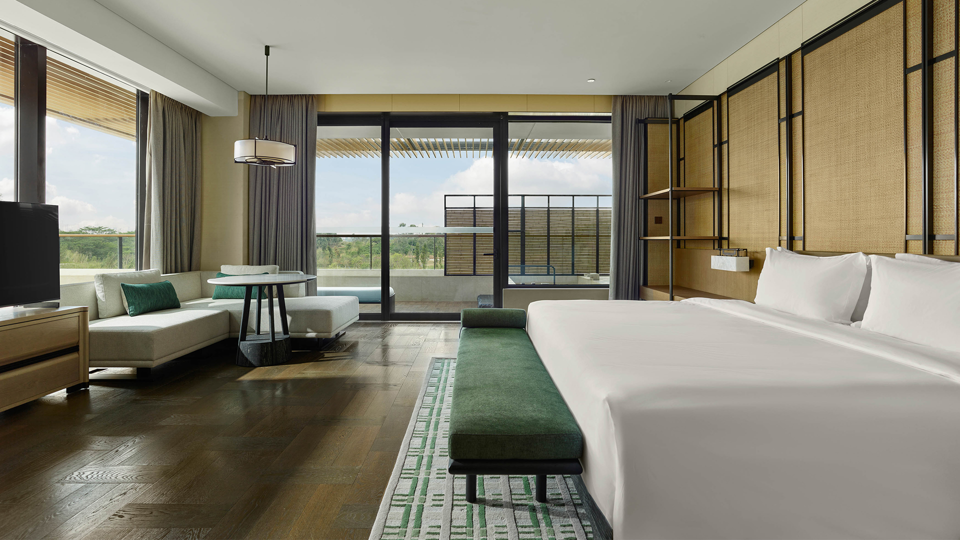 Spacious room with king bed and seating area, overlooking serene greenery at Banyan Tree Dongguan China.
