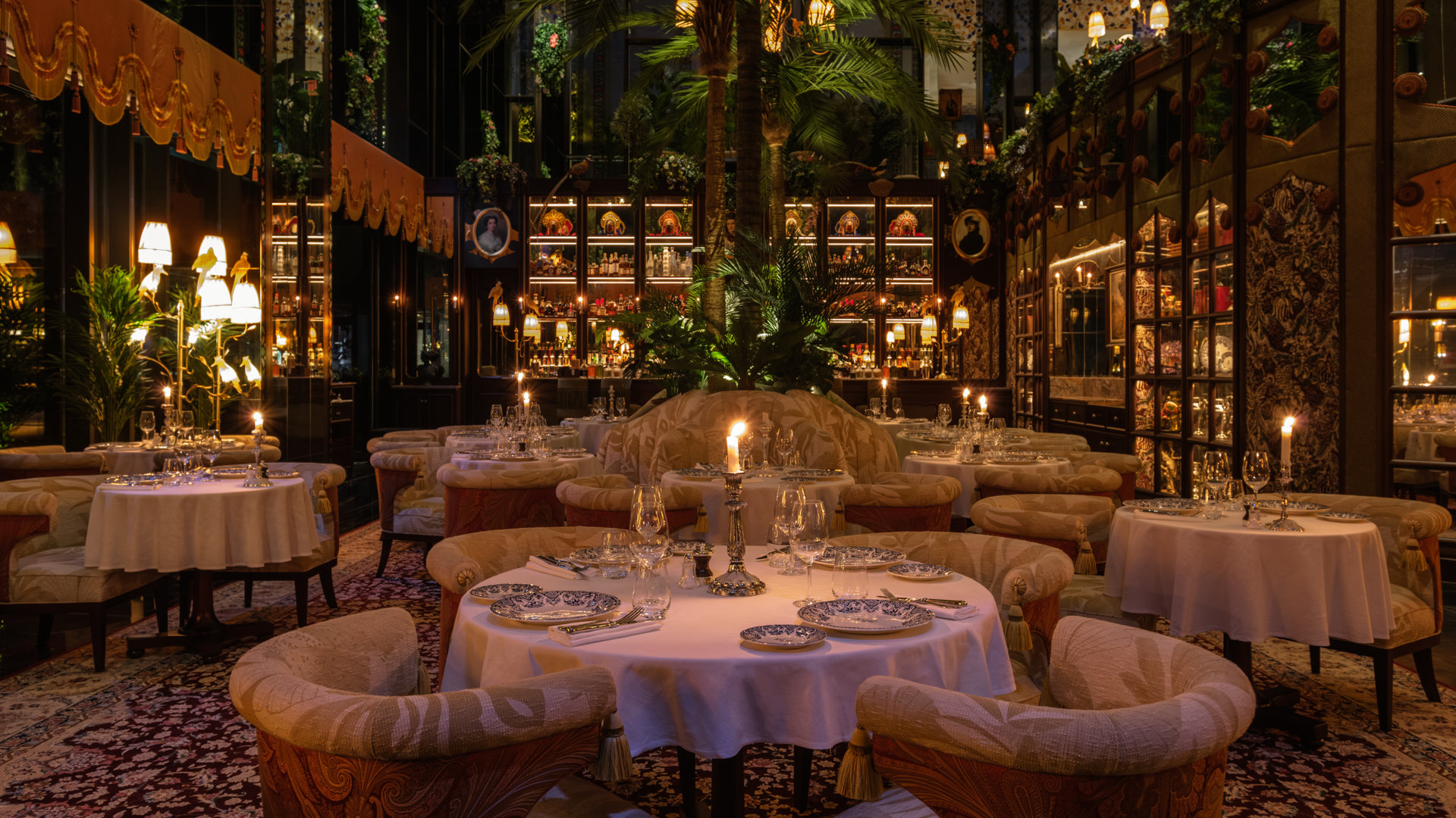 Candlelit tables, ornate decor enhance Banyan Tree Dubai Maison Revka restaurant's lavish ambiance.