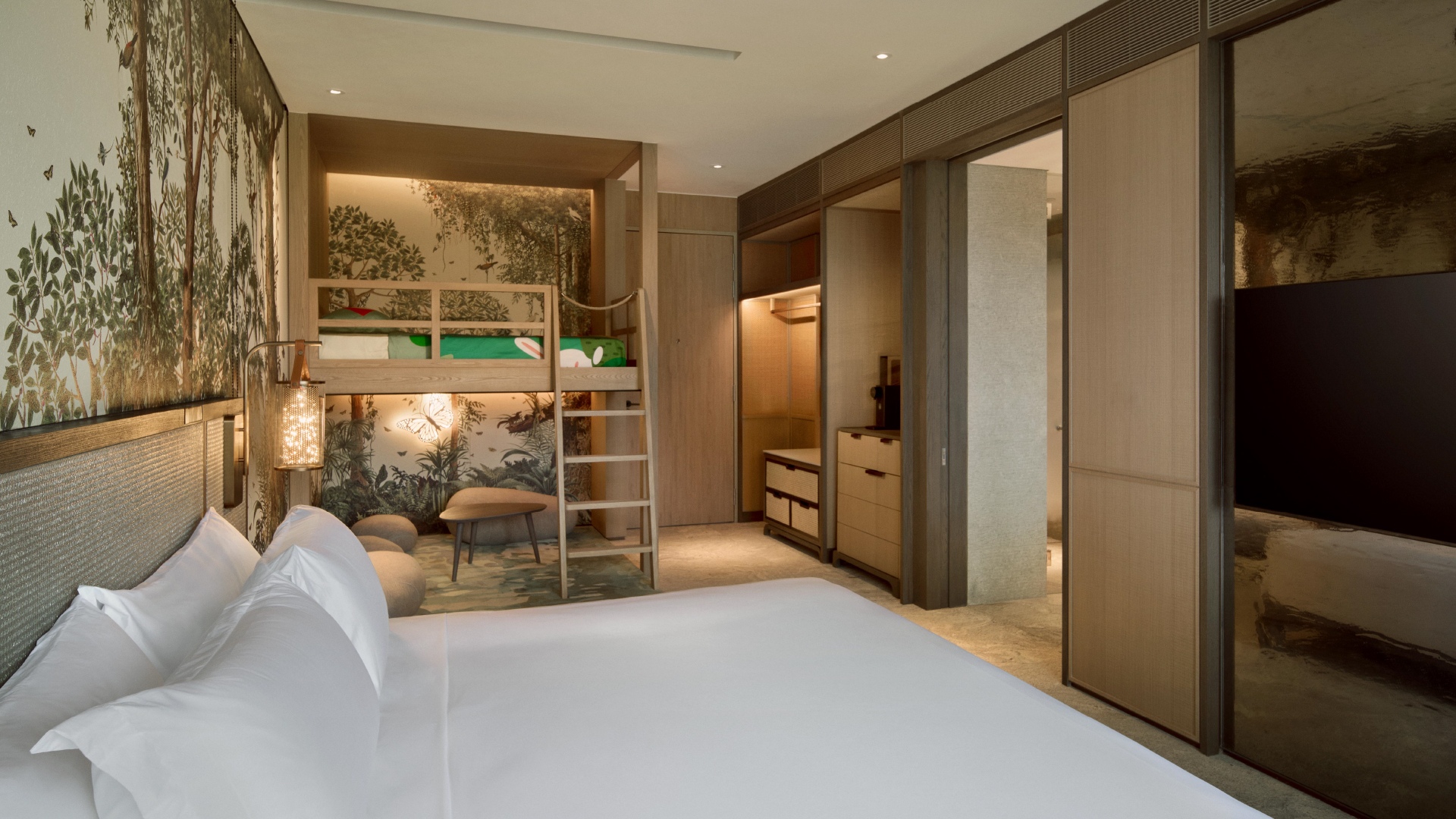 Kids-friendly bunk beds in a spacious Family Rainforest Room, adorned with nature-themed wallpaper.