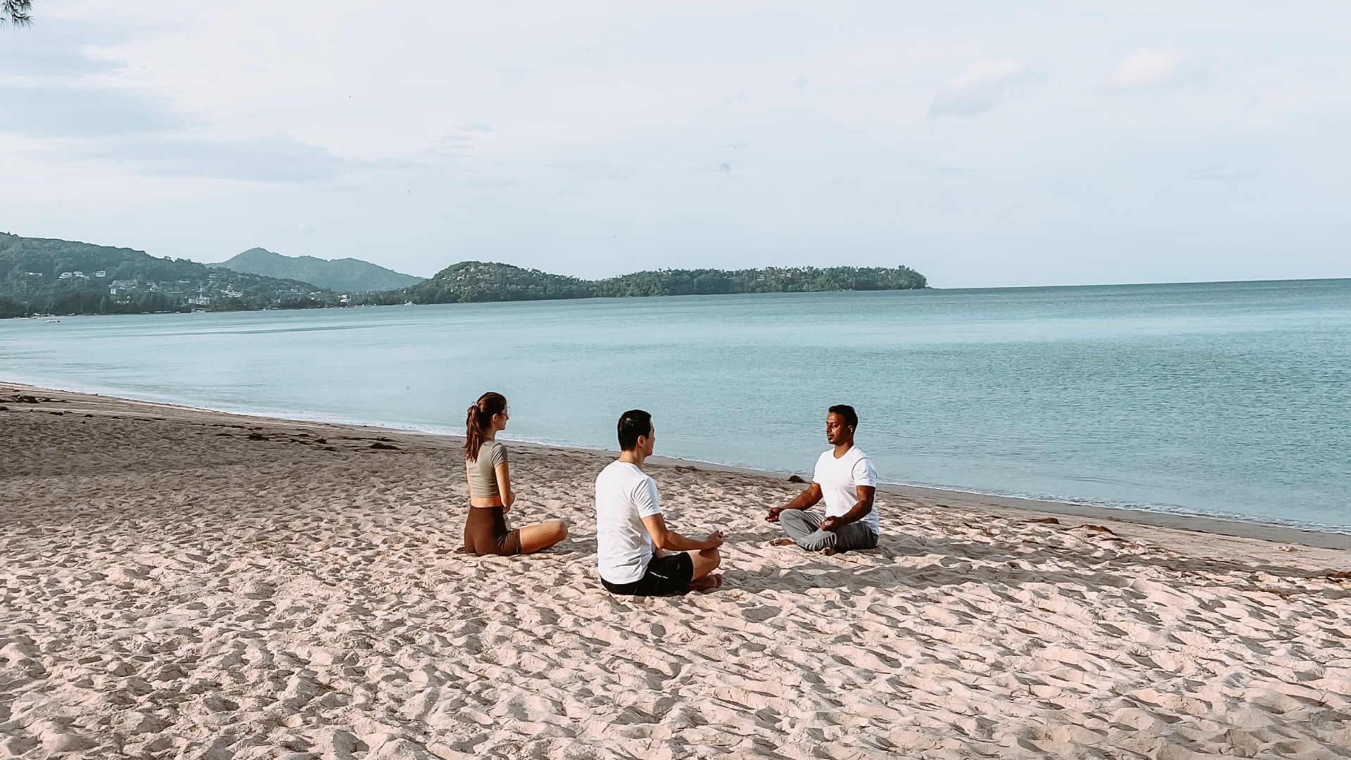 Couple practicing yoga on the beach