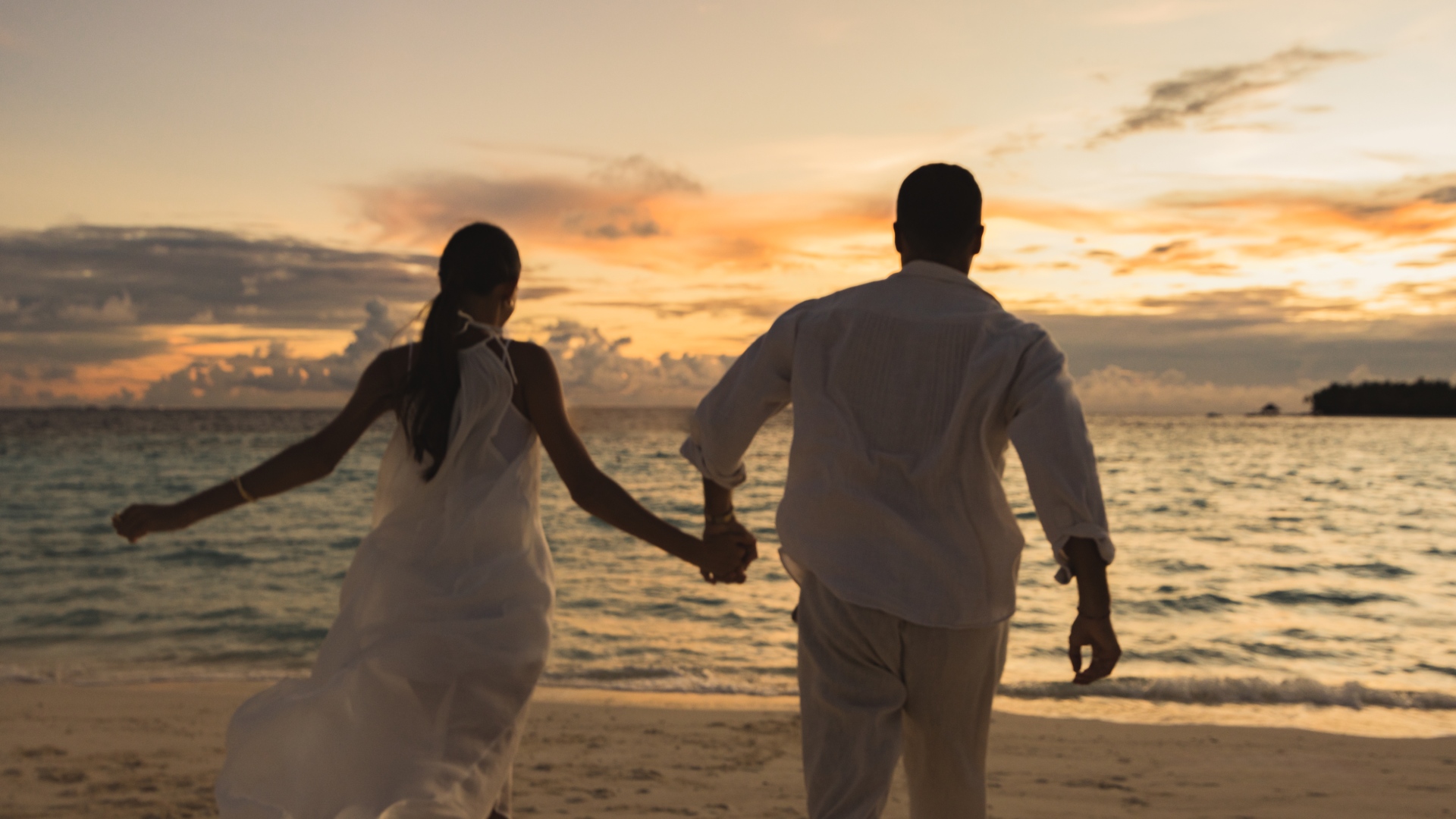 Couple holding hands on the beach