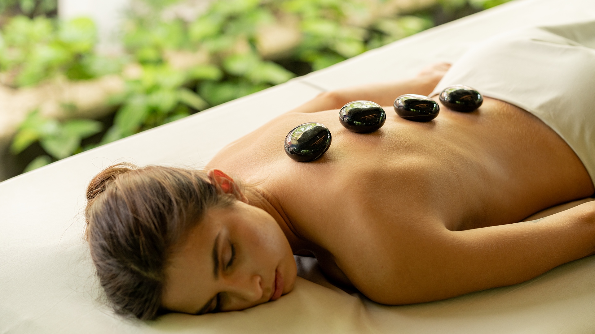 Woman with massage stones on her back
