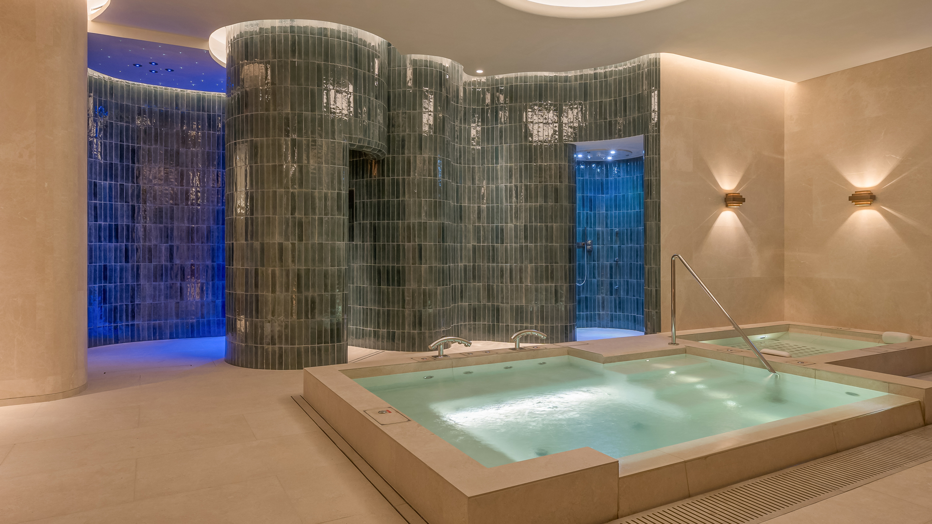 Rainforest hydrotherapy facility at Banyan Tree Dubai spa featuring therapeutic vitality pools, tropical rain showers, and curved tiled walls under ambient lighting for holistic wellness.