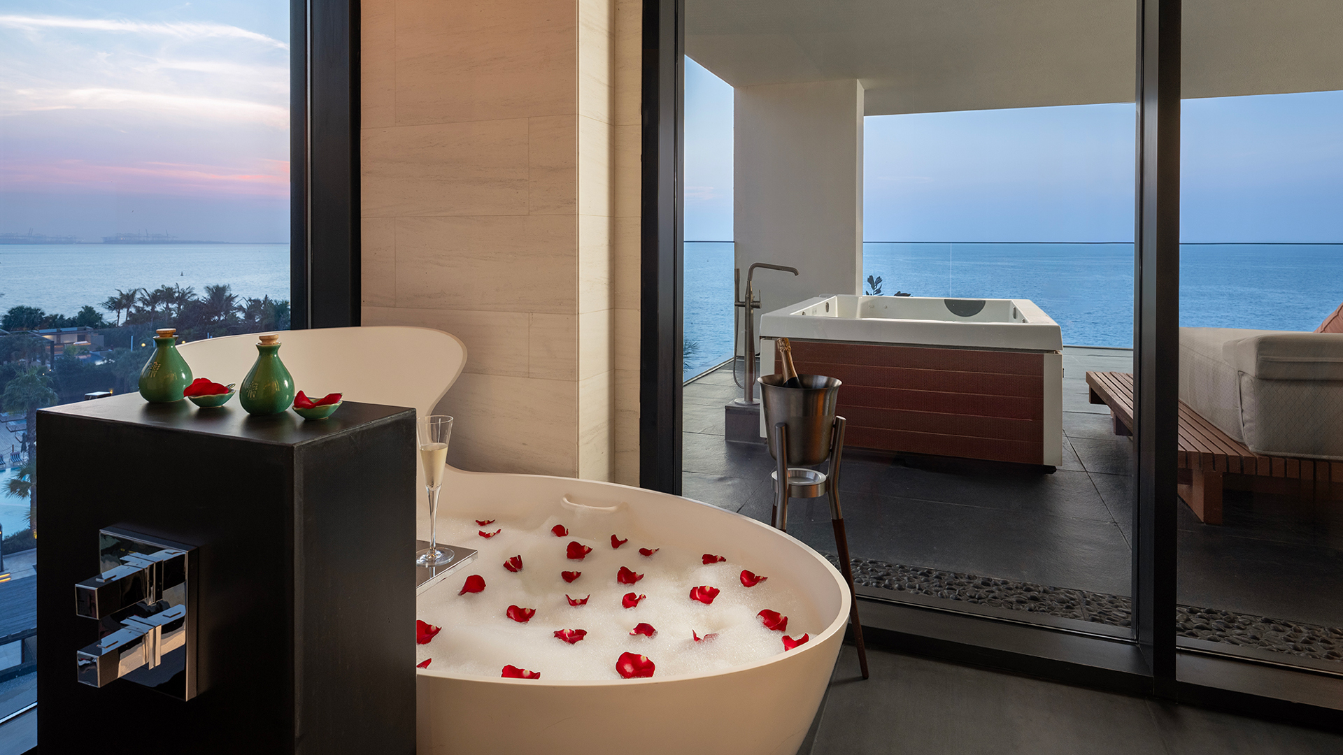 Romantic bath ritual at Banyan Tree Dubai featuring a rose petal bubble bath, outdoor jacuzzi, and panoramic Arabian Gulf views—perfect for luxury relaxation and sunset moments.