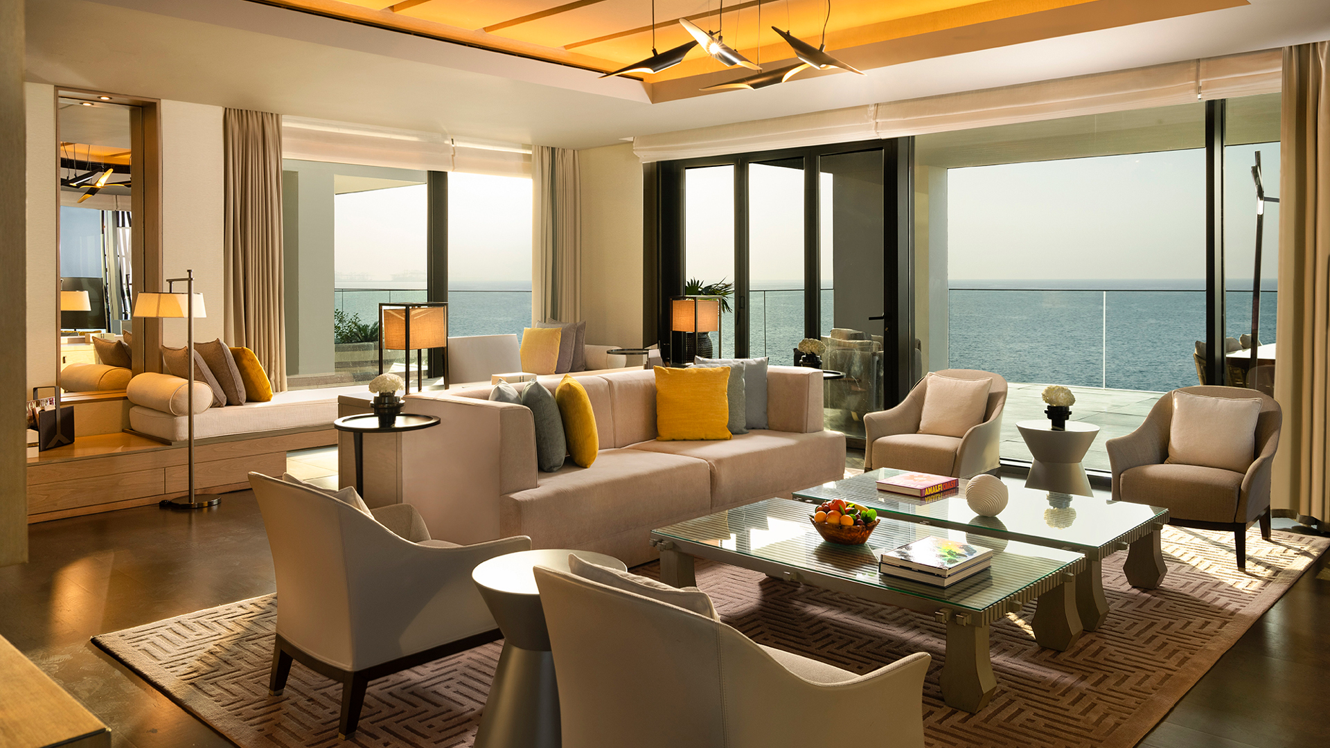 Sophisticated oceanfront living room in the Harmony Presidential Suite at Banyan Tree Dubai, featuring plush seating, contemporary décor, and floor-to-ceiling views of the Arabian Gulf.