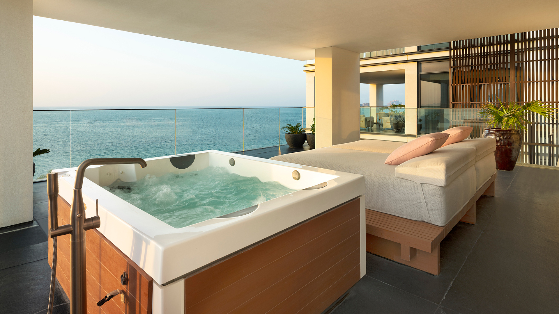 Expansive private terrace of the Harmony Oceanfront Presidential Suite at Banyan Tree Dubai, featuring an outdoor jacuzzi, daybeds, and uninterrupted views of the Arabian Gulf.