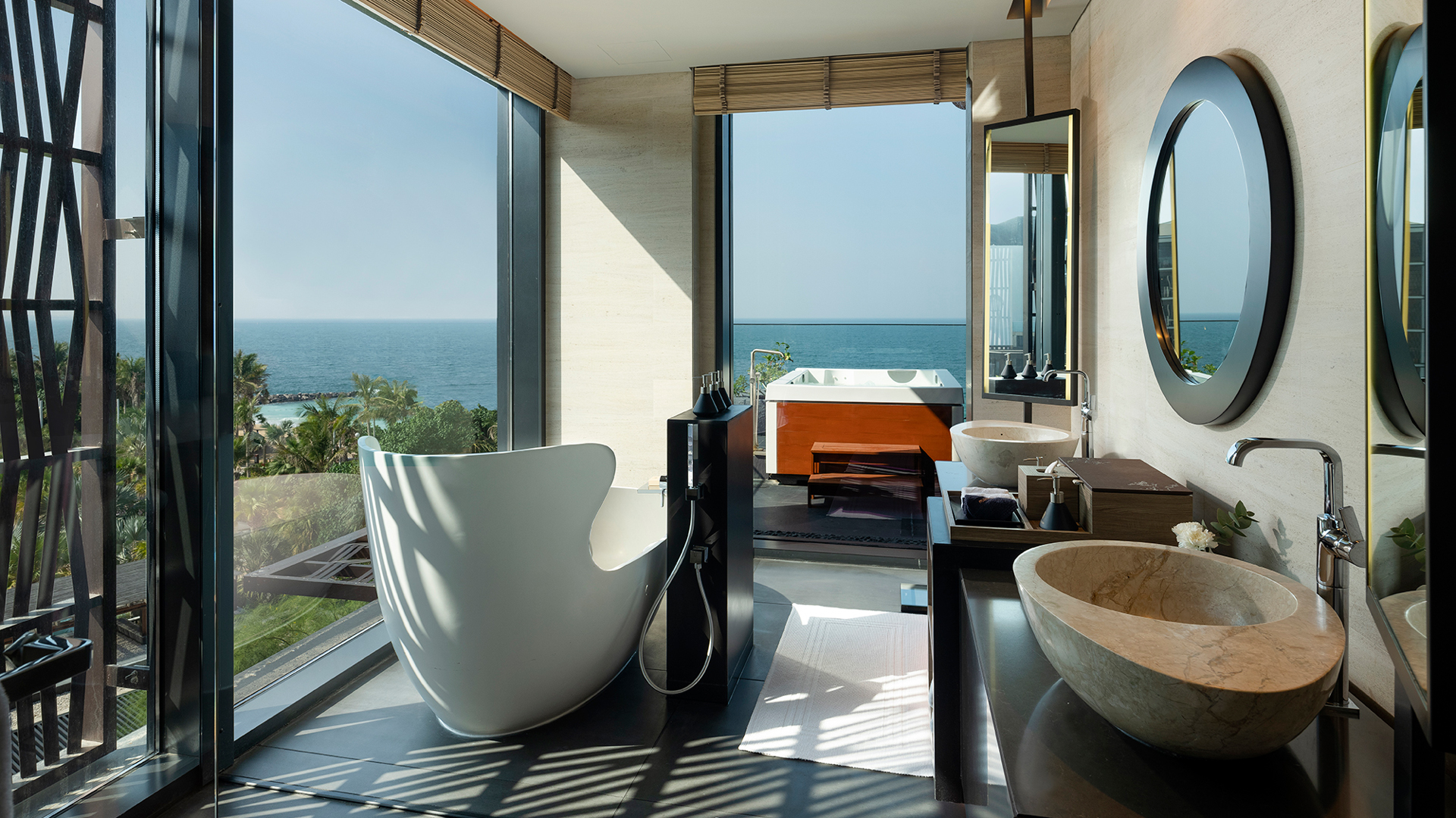 Luxurious ensuite bathroom in the Harmony Three-Bedroom Oceanfront Presidential Suite at Banyan Tree Dubai, featuring freestanding tub, dual stone basins, and panoramic sea views with an outdoor jacuzzi.