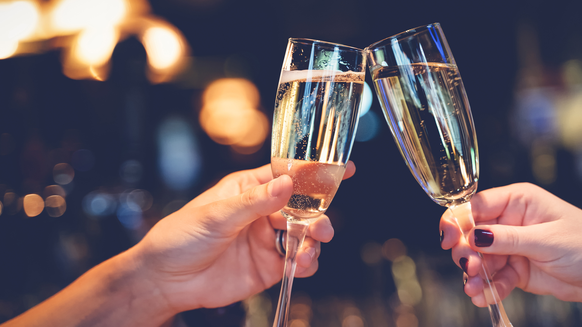 Two people cheers glasses of Champagne