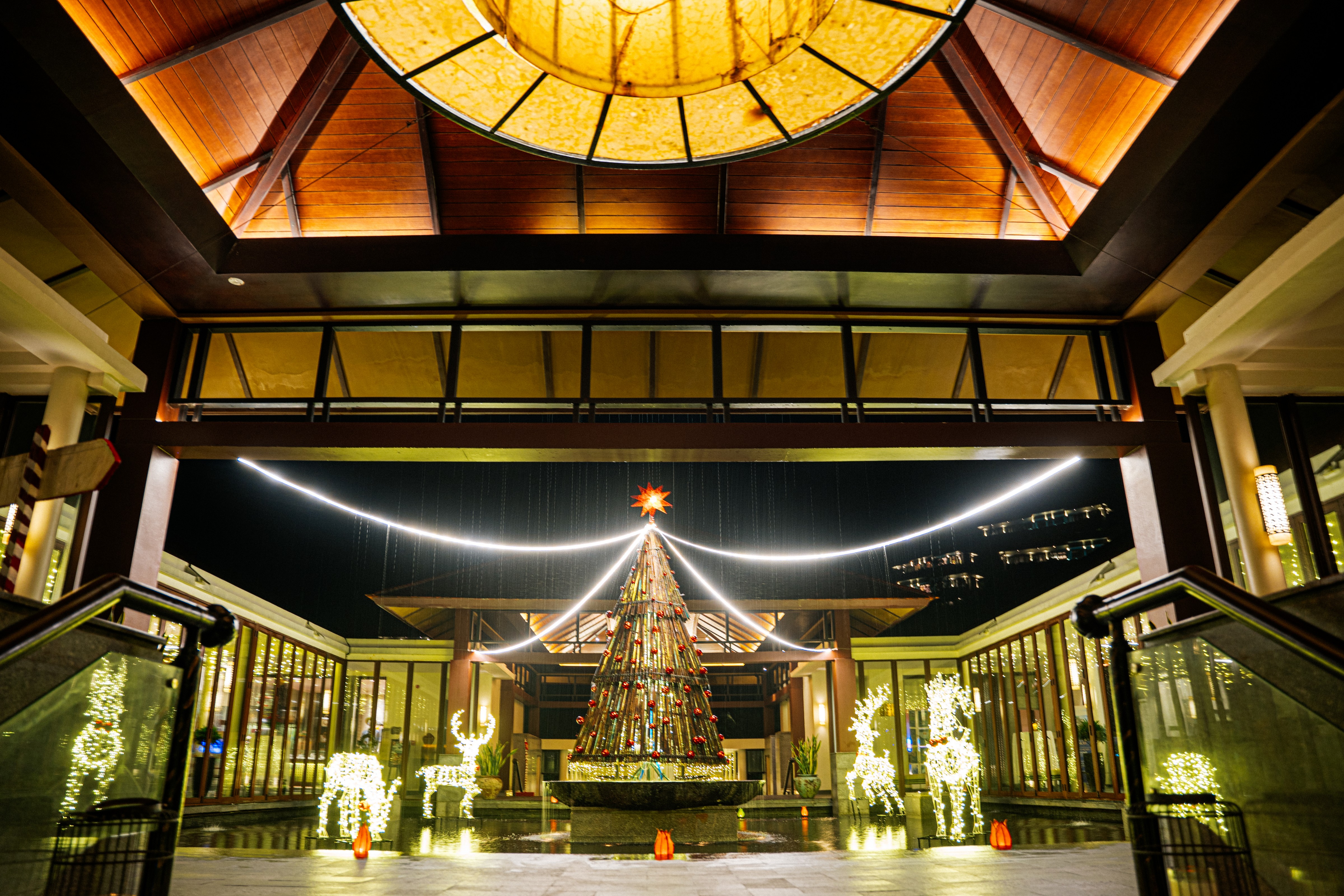Night view of the Christmas tree installation at the main entrance of Banyan Tree Lăng Cô with glowing holiday lights.