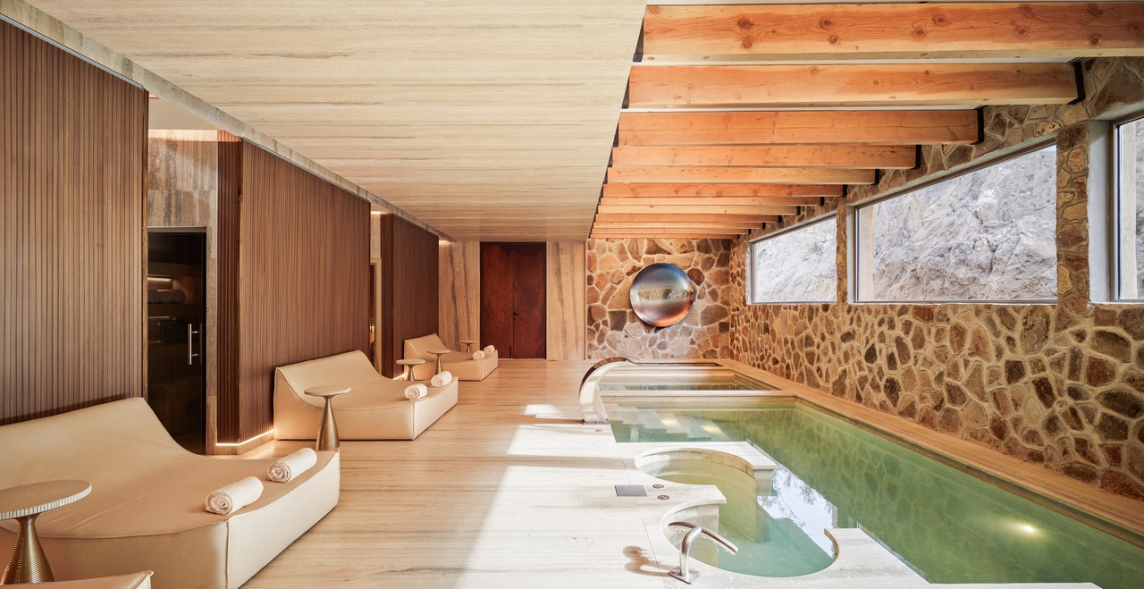 Indoor spa lounge featuring hydrotherapy pools, lounge beds, and natural stone walls at Veya de Guadalupe